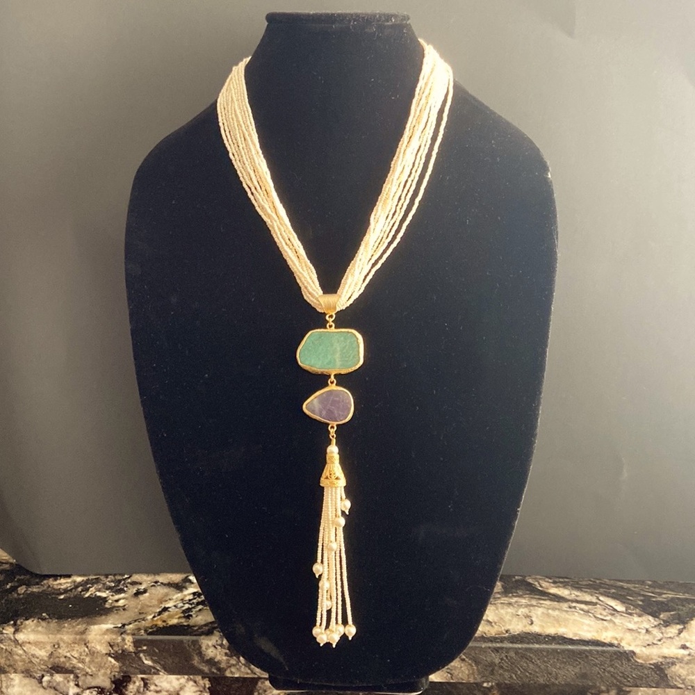 Long small ivory color pearl necklace.